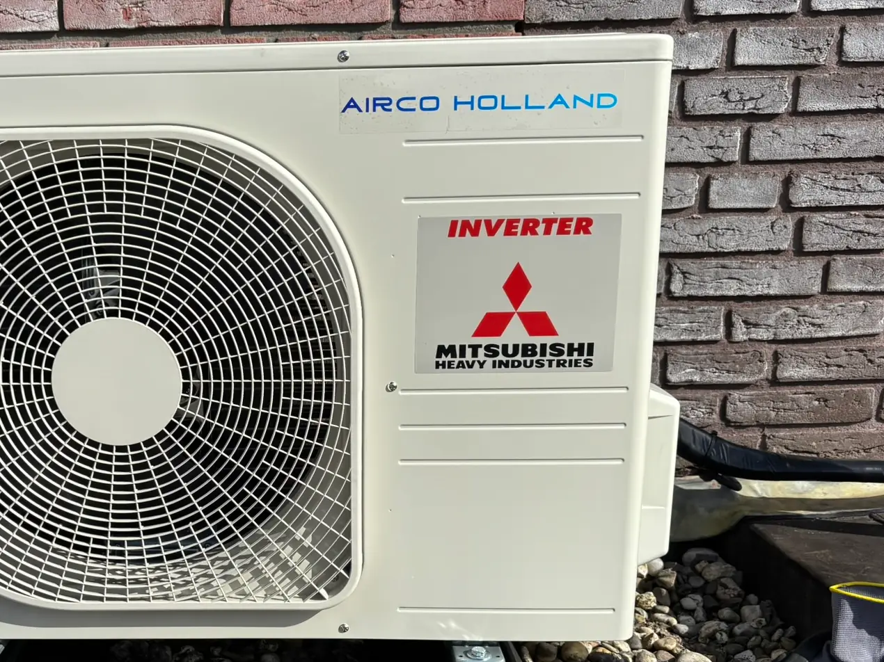 De stickers van Airco Holland en Mitsubishi Heavy Industries op een nieuwe buitenunit, van dichtbij.