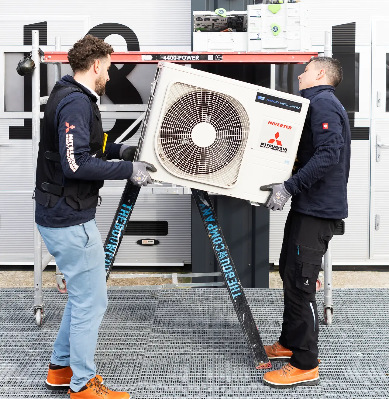 Rein (links) en Peter (rechts) tillen samen een nieuw buitendeel van Mitsubishi Heavy Industries.